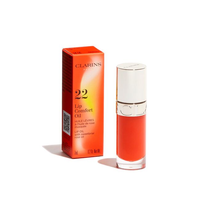 Packshot of the dark orange Clarins Lip Comfort Oil from the Power of Colors line, displayed alongside its packaging
